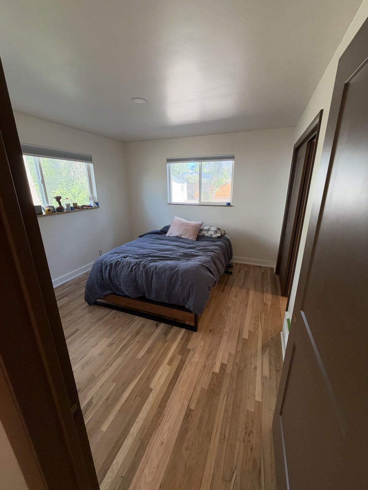 Sep 29, 2026. Master bedroom from the doorway, with a black bed, gray duvet, blinds, and brown doors