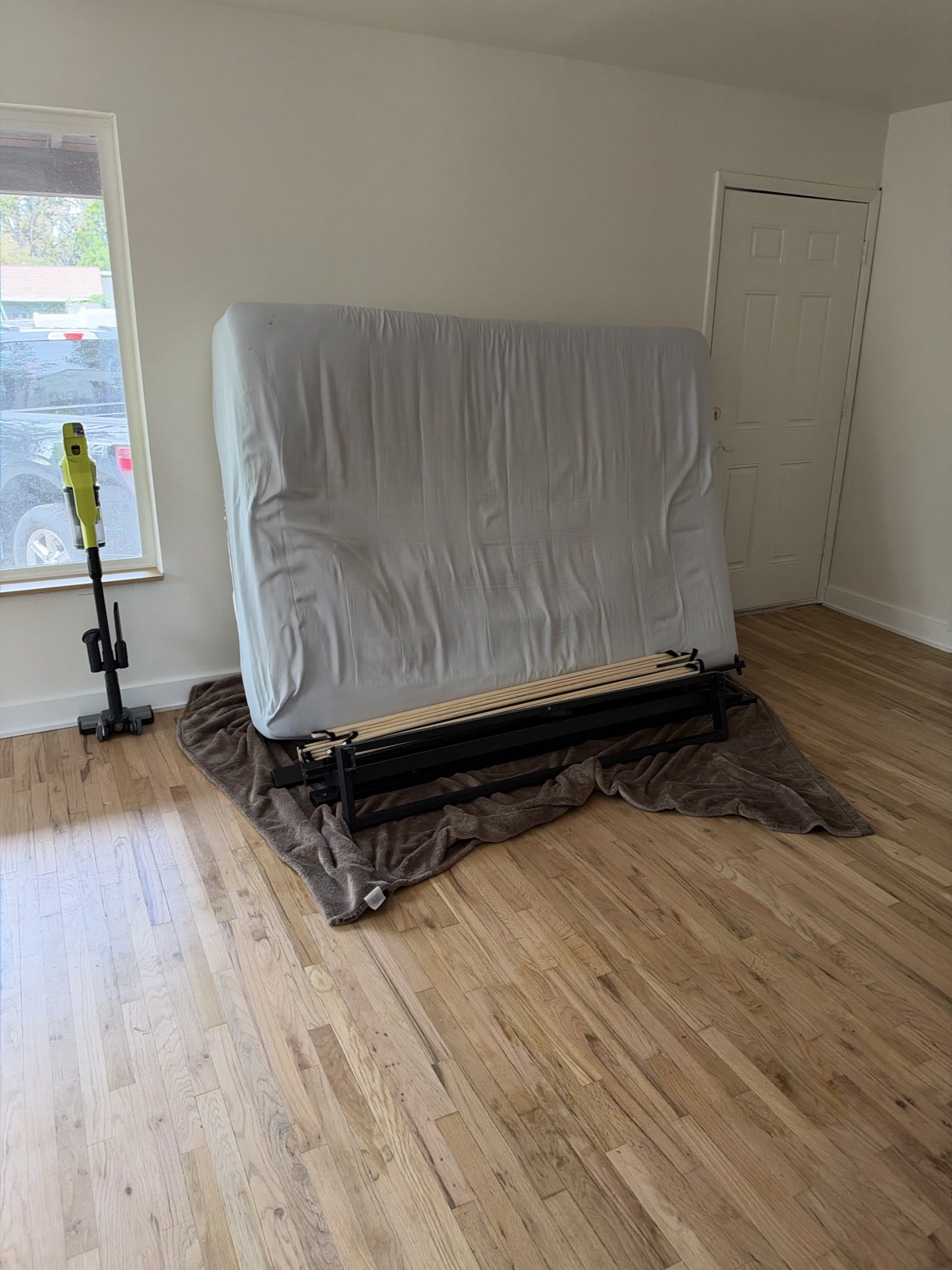 Sep 27, 2026. Mattress standing upright on a black bed frame with wood slats