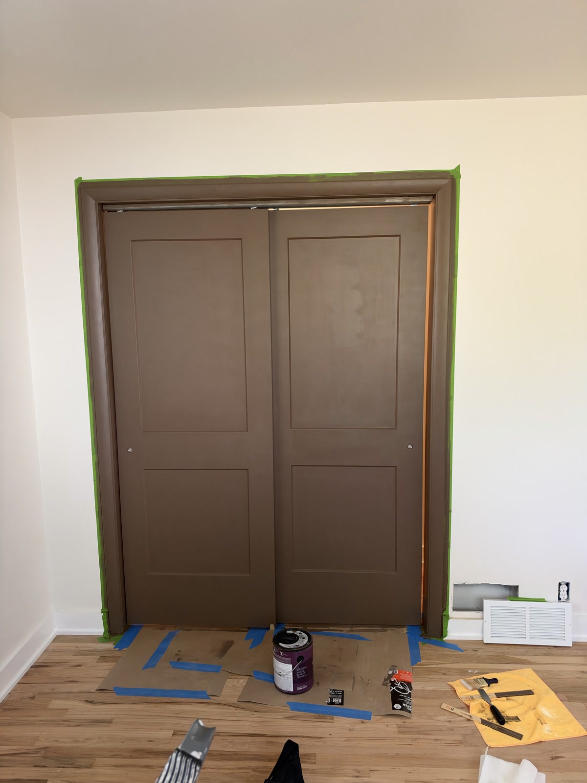 Sep 29, 2026. Brown sliding closet doors after paint, with supplies on the floor