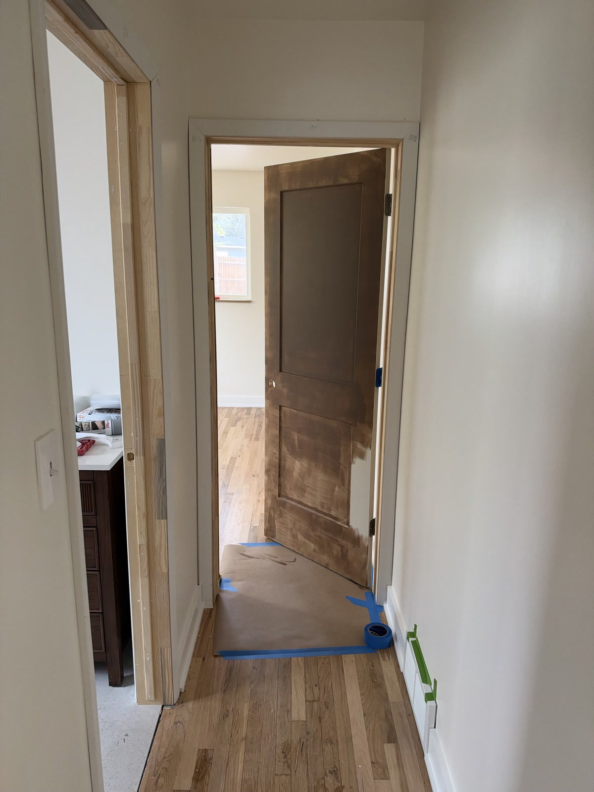 Sep 29, 2026. Hall door still mid-paint, brown on the face and raw wood on the jamb