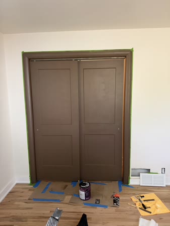 Sep 29, 2026. Brown sliding closet doors after paint, with supplies on the floor