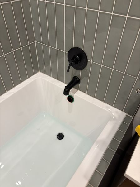 Sep 5, 2026 — Black tub faucet and controls installed against the sage green tile