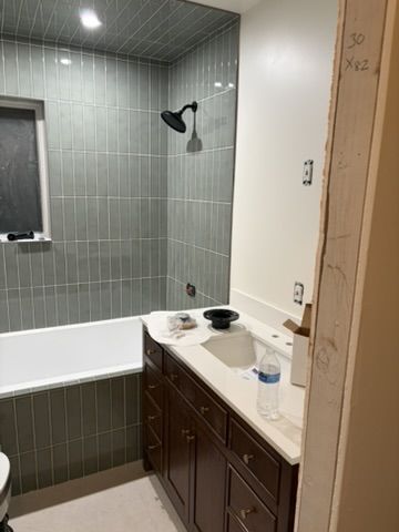 Sep 2, 2026 — Bathroom vanity beside the tiled tub surround and black showerhead