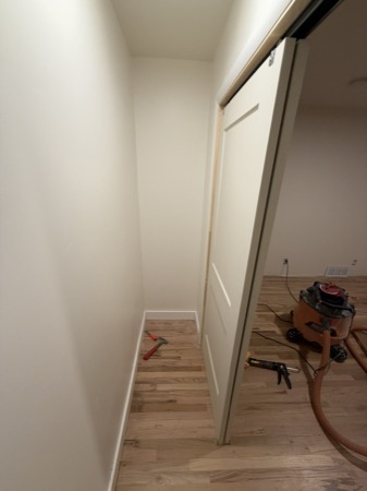 Sep 21, 2026 — Narrow closet with a sliding door, white trim, and finished hardwood floor